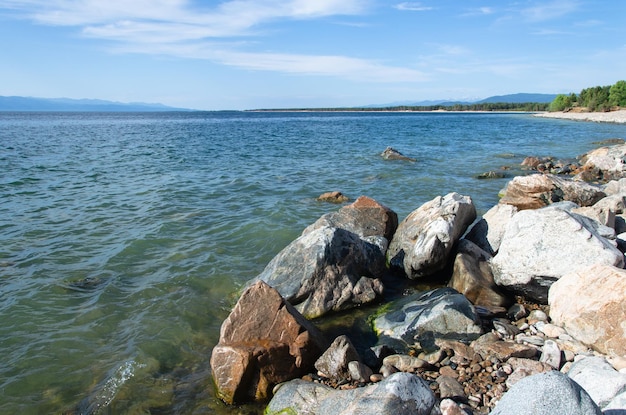 晴れた夏の天候でバイカル湖の岸にある石