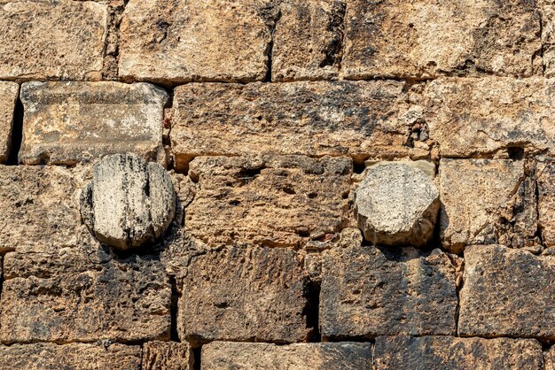 Muratura in pietra di un muro antico colonne antiche sono utilizzate tra i mattoni