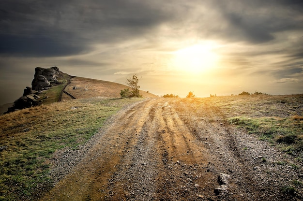 Stony road in mountains at the sunset