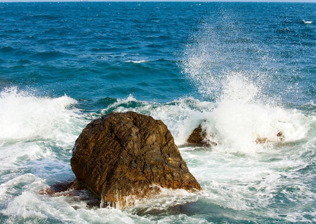 Stony sea coastline  and wave with splashes