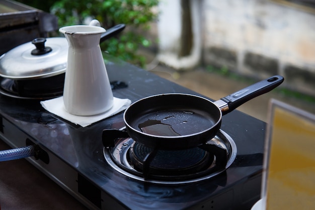 Stookolie in roestvrijstalen pan op gasgestookte kachel voor het frituren van voedsel in de buitenkeuken