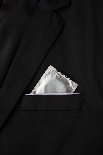 Stop aids and hiv concept. closeup condoms in a black suit background