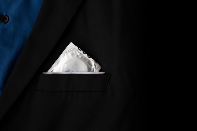 Stop aids and hiv concept. closeup condoms in a black suit background