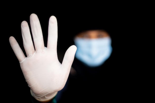 Foto stop coronavirus een jonge aziatische vrouw die een gezichtsmasker en medische rubberen handschoenen draagt