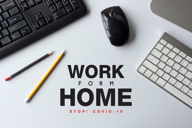 Ferma il concetto covid-19. lavoro da casa. vista dall'alto dell'area di lavoro della scrivania con penna e tastiera sul tavolo bianco