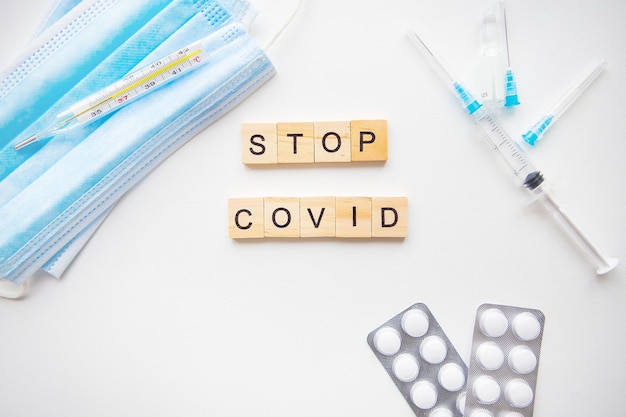 Stop de inscriptie van het coronavirus Voorbereiding voor vaccinatie tegen covid19 Spuitvaccinpillen medisch masker