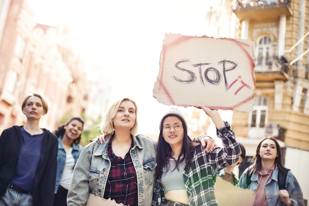 Stop geweld tegen vrouwen twee jonge vrouwen houden een spandoek vast met het woord stop it