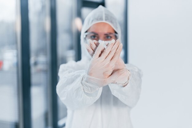 Stop het virusteken. Portret van vrouwelijke arts wetenschapper in laboratoriumjas, eyewear verdediging en masker