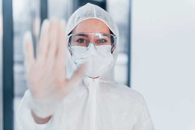 Stop het virusteken. portret van vrouwelijke arts wetenschapper in laboratoriumjas, eyewear verdediging en masker