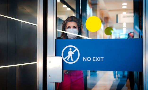 Stop infection. woman shows stop gesture through glass door there is no exit.