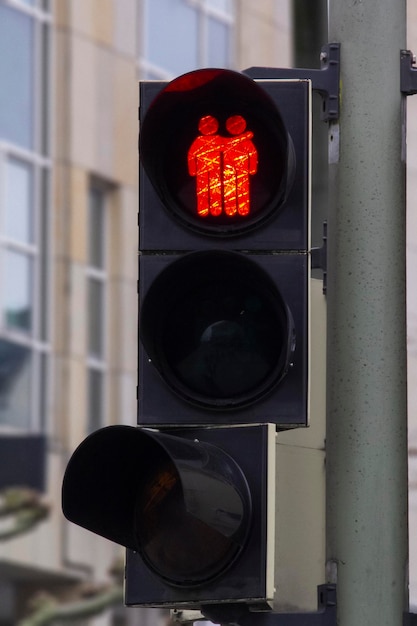 A stop light with a man and a woman on it