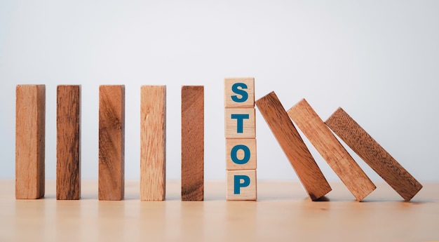 Stop met bewoording afdrukken op houten blokkubus, bescherm houten vallende dominosteen voor risicobeheerconcept