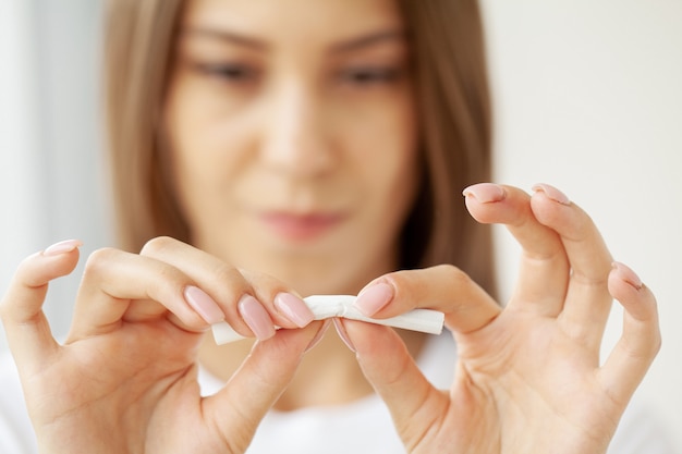 Stop met roken, close-up van vrouw brekende sigaret