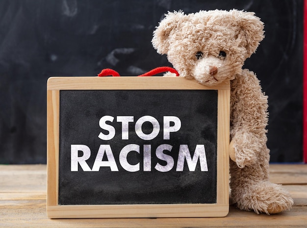 Stop racismetekst en schattige teddybeerschool op schoolbordachtergrond