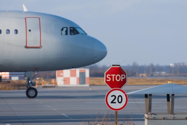 Stop sign on the road service vehicles on the platform of the airport the aircraft's nose