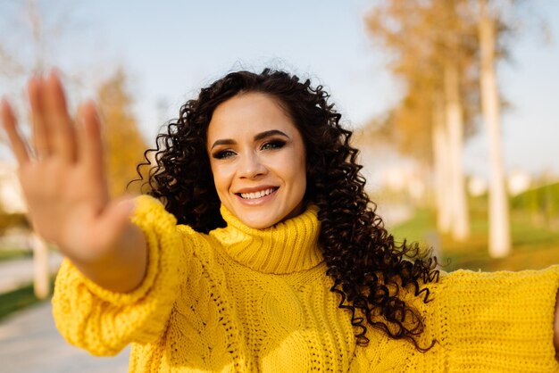 Знак "Стоп" с рукой показывает девушку в яркой одежде в осеннем парке