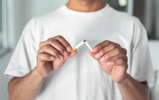 Stop smoking cigarettes concept. Portrait of beautiful  holding broken cigarette in hands. Happy , health care concept. No smoking.