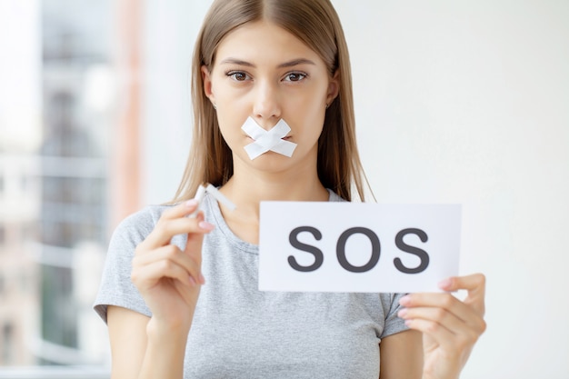 Stop smoking, a woman with a sealed mouth holding a broken cigarette