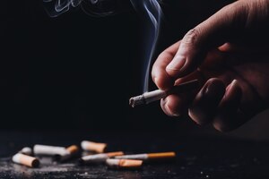 Stop smoking .world no tobacco day.close up a hand holding a crumpled, smoldering cigarette with smoke hand smoking cigarette ,unhealthy lifestyle