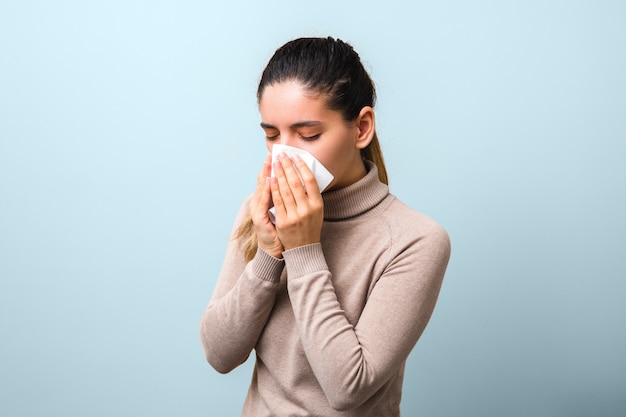 Stop spreading coronavirus. young sick woman with fly or virus sneezing and coughing in a mask or napkin looking very hopeless