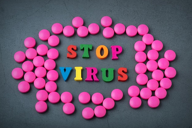 Stop the virus in a frame of scattered tablets.