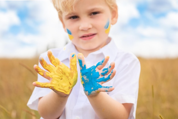 Stop War in Ukraine Ukrainian boy with Ukrainina flag yellow and blue painted on the hands stands against war