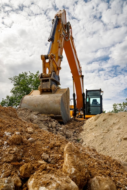 A stopping yellow excavator for rest at a construction site Vertical view