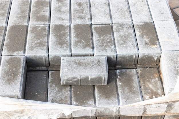 Storage of paving slabs on pallets at the construction site. Ready-to-install concrete paving slabs. Finished products warehouse.
