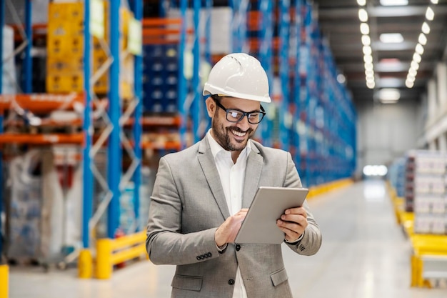 a storage worker is using tablet for tracking goods and shipment online while scrolling