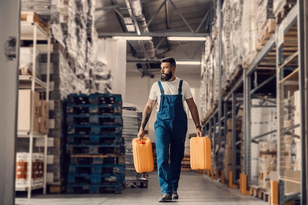 A storage worker relocating cans with oil