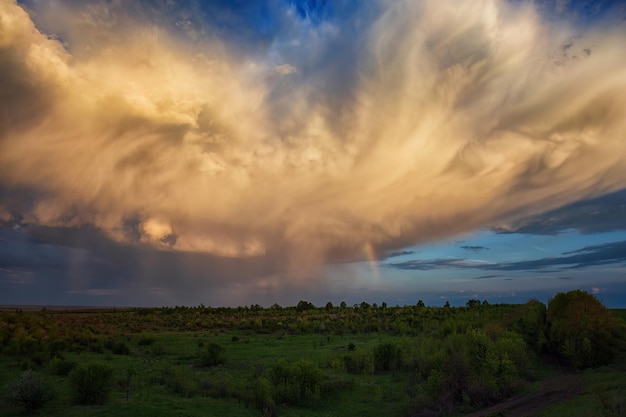 Storm cloud after rain over the valley and a rainbow