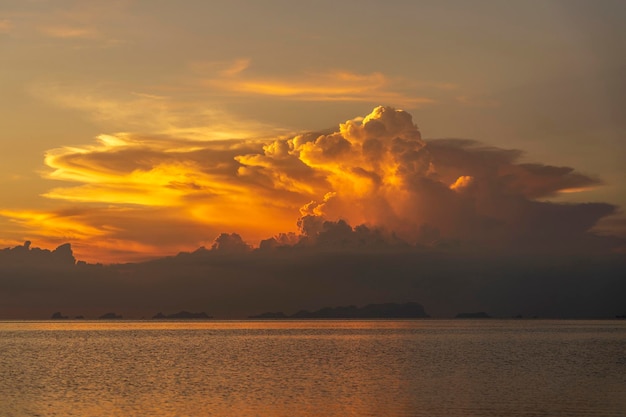 日没時の嵐の雲熱帯のビーチの近くの穏やかな海に沈む美しい夕日夏休みのコンセプト島パンガンタイ