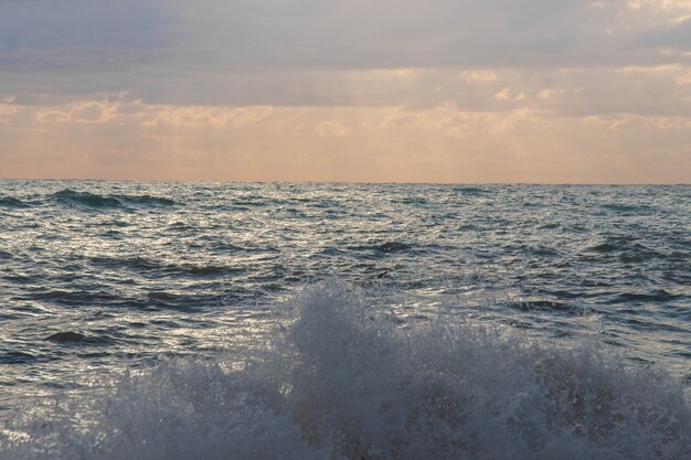 Storm on the sea in the rays of sunset big waves, spray.