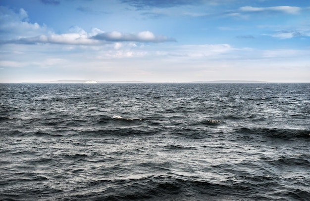 Storm waves in the White Sea near the Solovetsky Islands and a white ship on the horizon