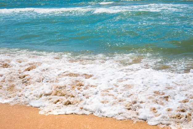 A stormy sea wave with foam rolled onto the sandy shore Seascape natural background