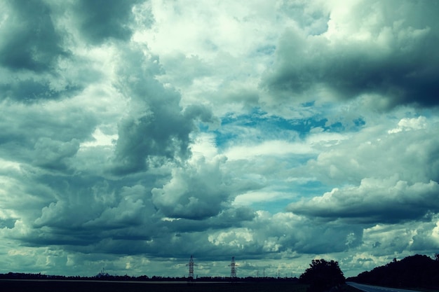 Stormy sky with clouds and electricity pylon Nature background