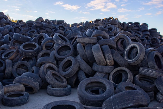 Stortplaats met oude banden en banden voor recycling Hergebruik van afgedankte rubberbanden Verwijdering van gebruikte banden Gebruikte wielen voor recycling
