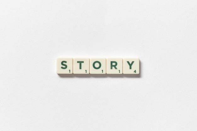 Story formed of scrabble tiles on white background