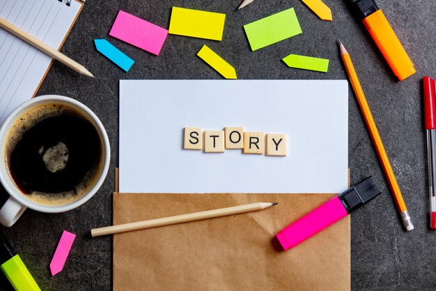 Story letters on paper sheet and notes around with coffee cup on a table