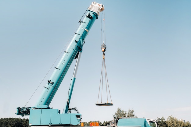 The stove is loaded onto a large blue car crane and prepared for operation .