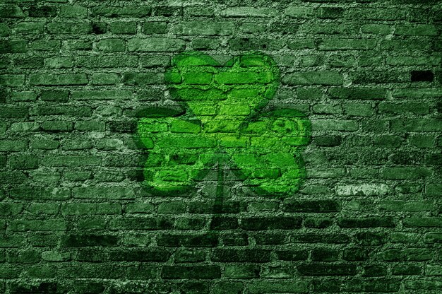 Photo stpatrick s day green brick wall with clover sign