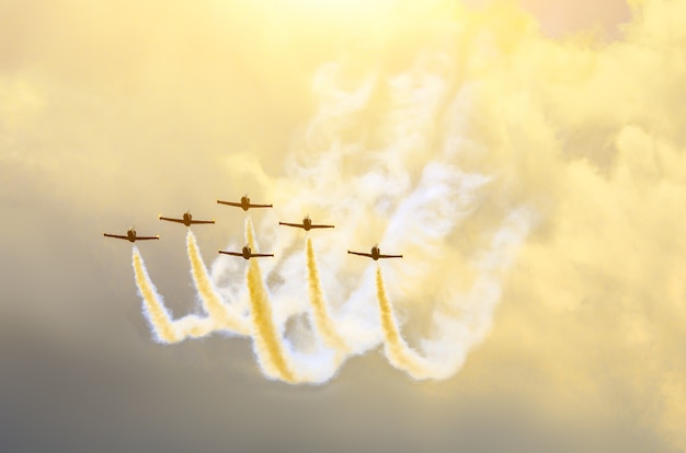 Straaljagers van vliegtuigen roken de achtergrond van luchtwolken en zon.