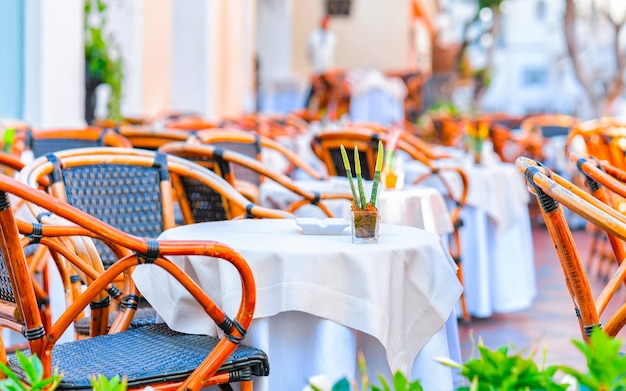 Straat café en restaurant tafel en stoel op Capri Island stad in Italië in Napels. Landschap met terrascafetaria aan de Italiaanse kust. Anacapri in Europa. Zomer. Amalfi landschap. Amalfina kustlijn.