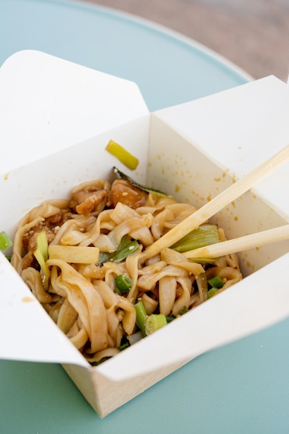 Foto straat eten buiten aziatische noedels met groenten en specerijen in papieren dozen buiten eten