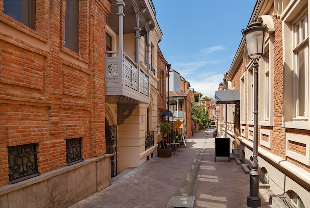 Straat in georgië tbilisi aan de zijkanten van een huis gemaakt van bakstenen. georgië tbilisi straat.