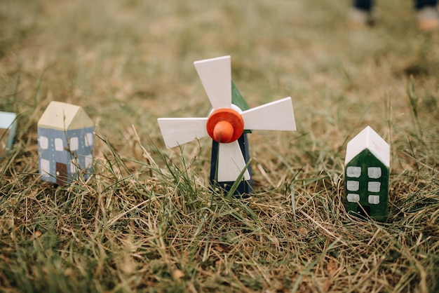 Straat met houten speelgoedhuisjes en windmolens op het gras Kleine speelgoedhuisjesmolen