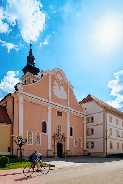 Straat met katholieke kerk van de Hemelvaart van de Maagd Maria in de oude stad in Varazdin in Kroatië. Stadsgezicht van de buitenkant van de kathedraalgevel in de beroemde Kroatische stad in Europa, zomer. Blauwe lucht op de achtergrond