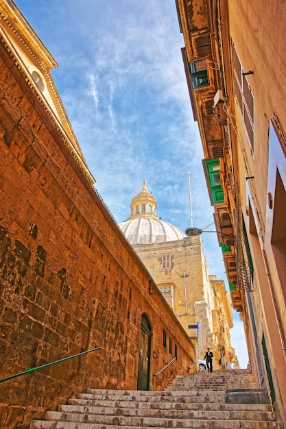 Straat met trap en koepel van de Karmelietenkerk in de oude stad Valletta, Malta