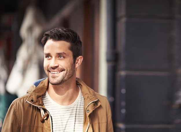 Straat stedelijke mode en gelukkige man op de stoep met glimlach op gezicht mockup en zonneschijn buiten café Geluk streetwear en hipster mannelijk model wandelen in de stad ontspannen en sightseeing op vakantie