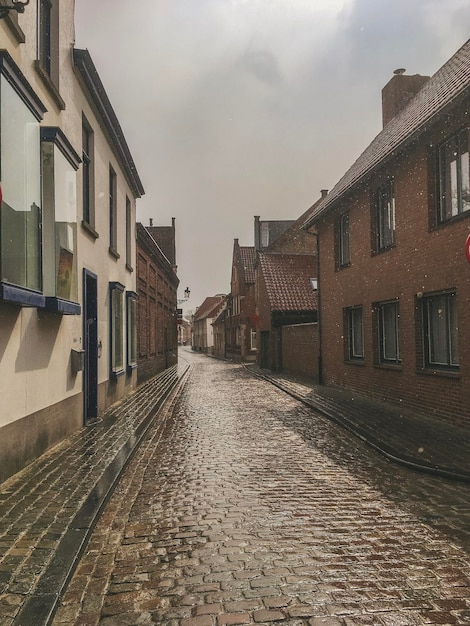 Straat te midden van gebouwen tegen de lucht tijdens het regenseizoen